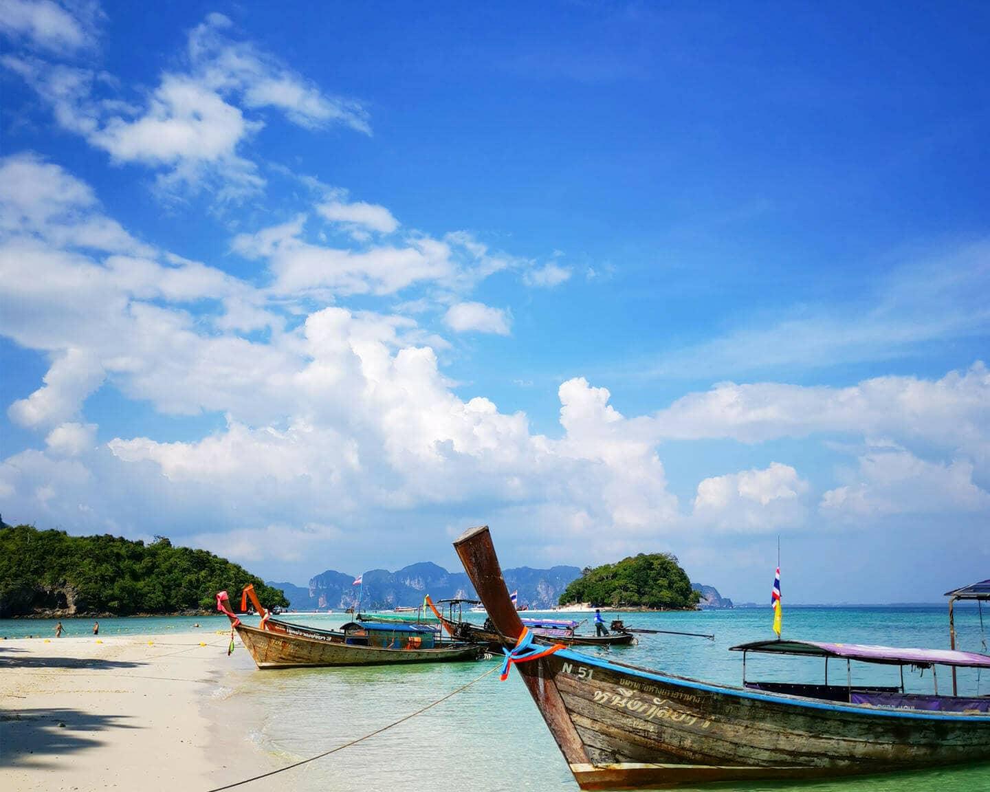 En Tailandia, se llega mejor a las islas en barcos de cola larga y se disfruta de la vista al mar.