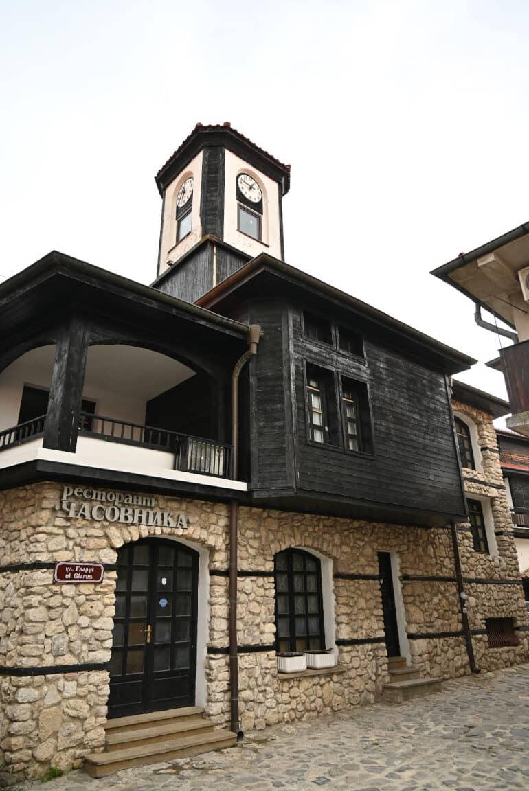 Un edificio con la parte superior totalmente de madera negra y un campanario en la ciudad búlgara de Nessebar.