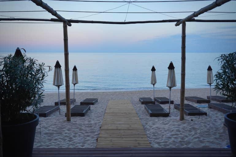 La playa Radjana Beach al amanecer con tumbonas y sombrillas: una playa desconocida en Bulgaria.