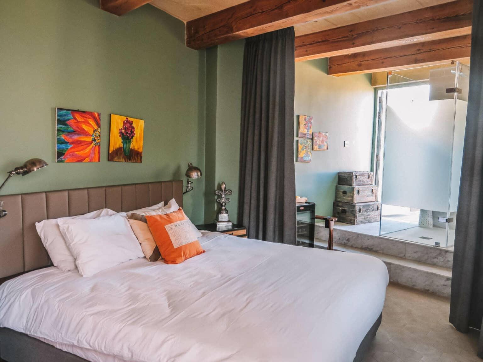 A bedroom with a bed and a green-painted wall.