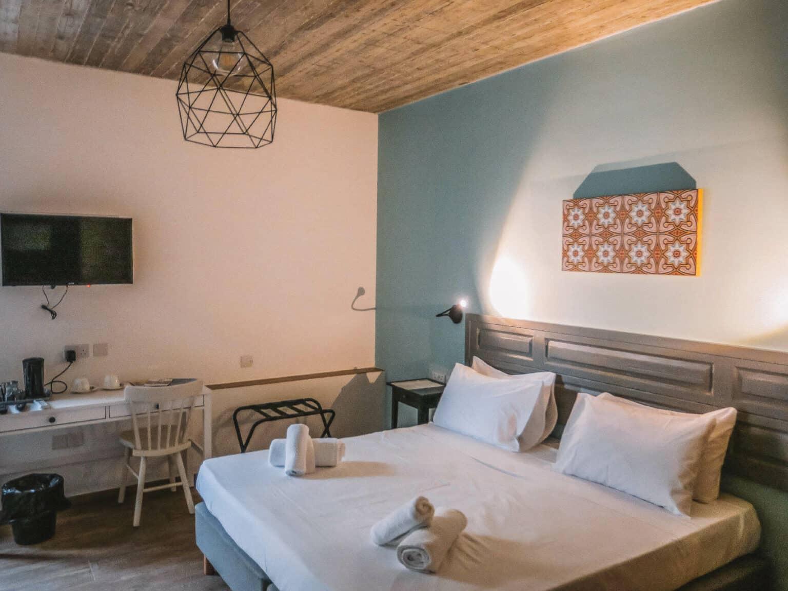A bedroom with a bed and a blue-painted wall.
