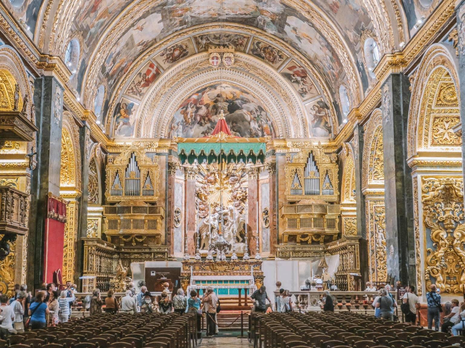An old church from the inside with a few people.