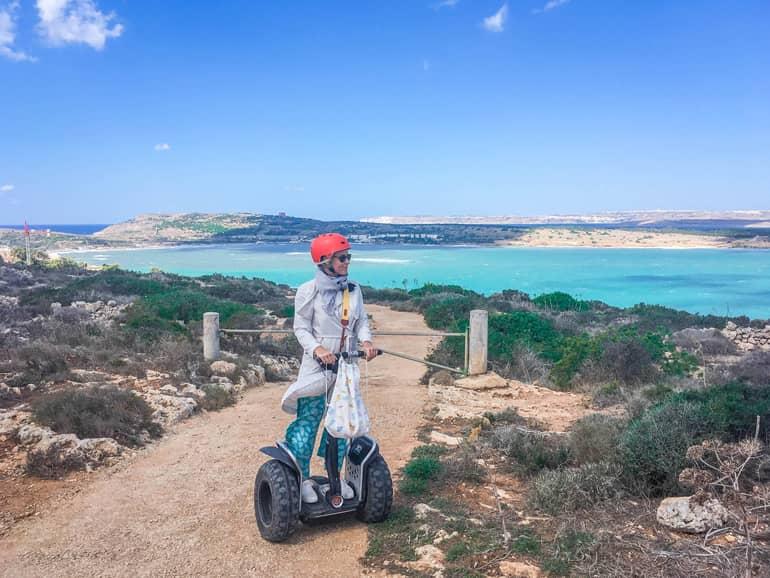 Woman stands on a Segway at a viewpoint in Selmun