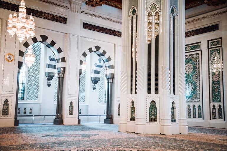 En el interior de la Mezquita Sultan Qabus, cerca de Mascate, Omán, se pueden ver finos mosaicos en las altas columnas blancas y arcos, y una enorme alfombra de oración.