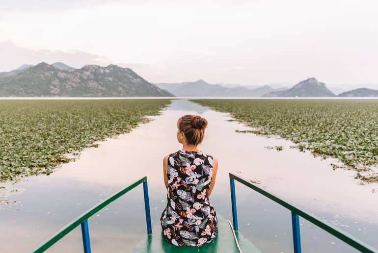 Una mujer está en un barco navegando por un lago.