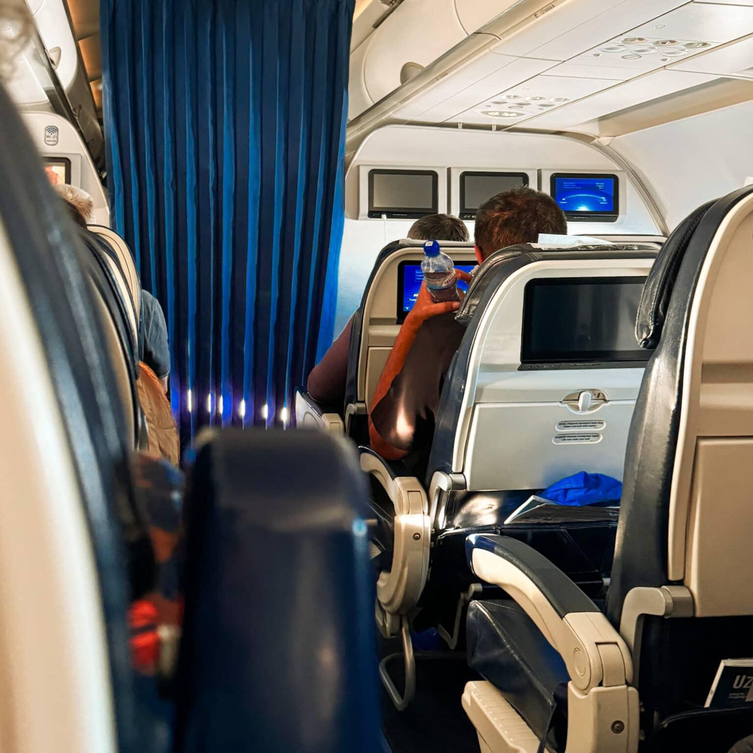 Un recorte con algunos asientos de la cabina de un avión de la aerolínea Uzbekistan Airways.