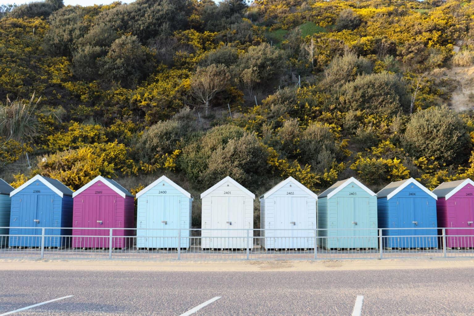 Las coloridas cabañas de playa Boscombe Beachhuts están alineadas a lo largo de una calle en el sur de Inglaterra.