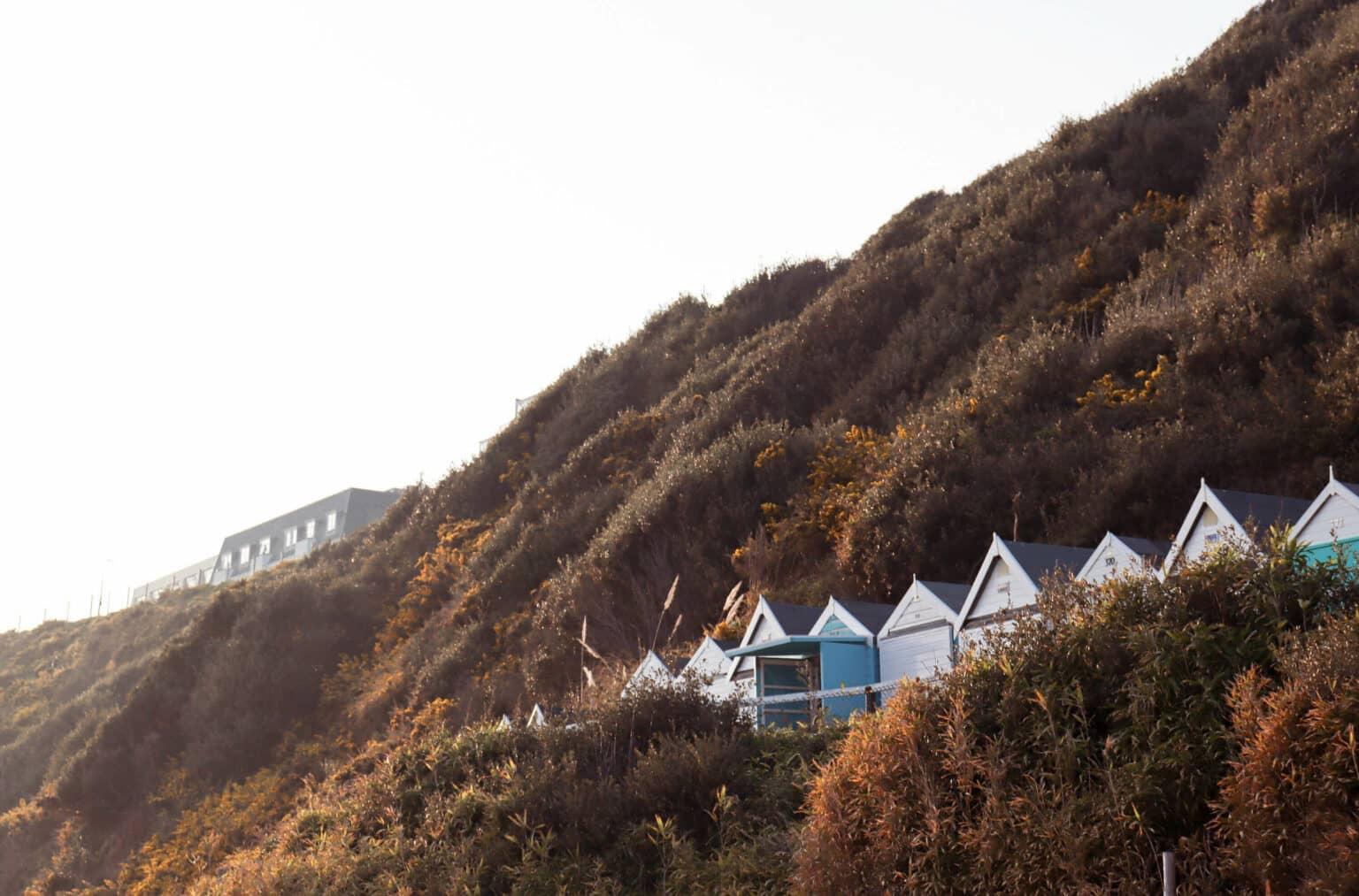 Cabañas de playa en medio de colinas verdes en Boscombe Beach.