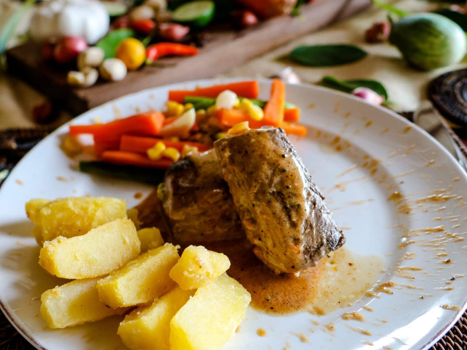 A plate of potatoes, meat, and vegetables from the Katembe Private Island Resort in Raja Ampat.
