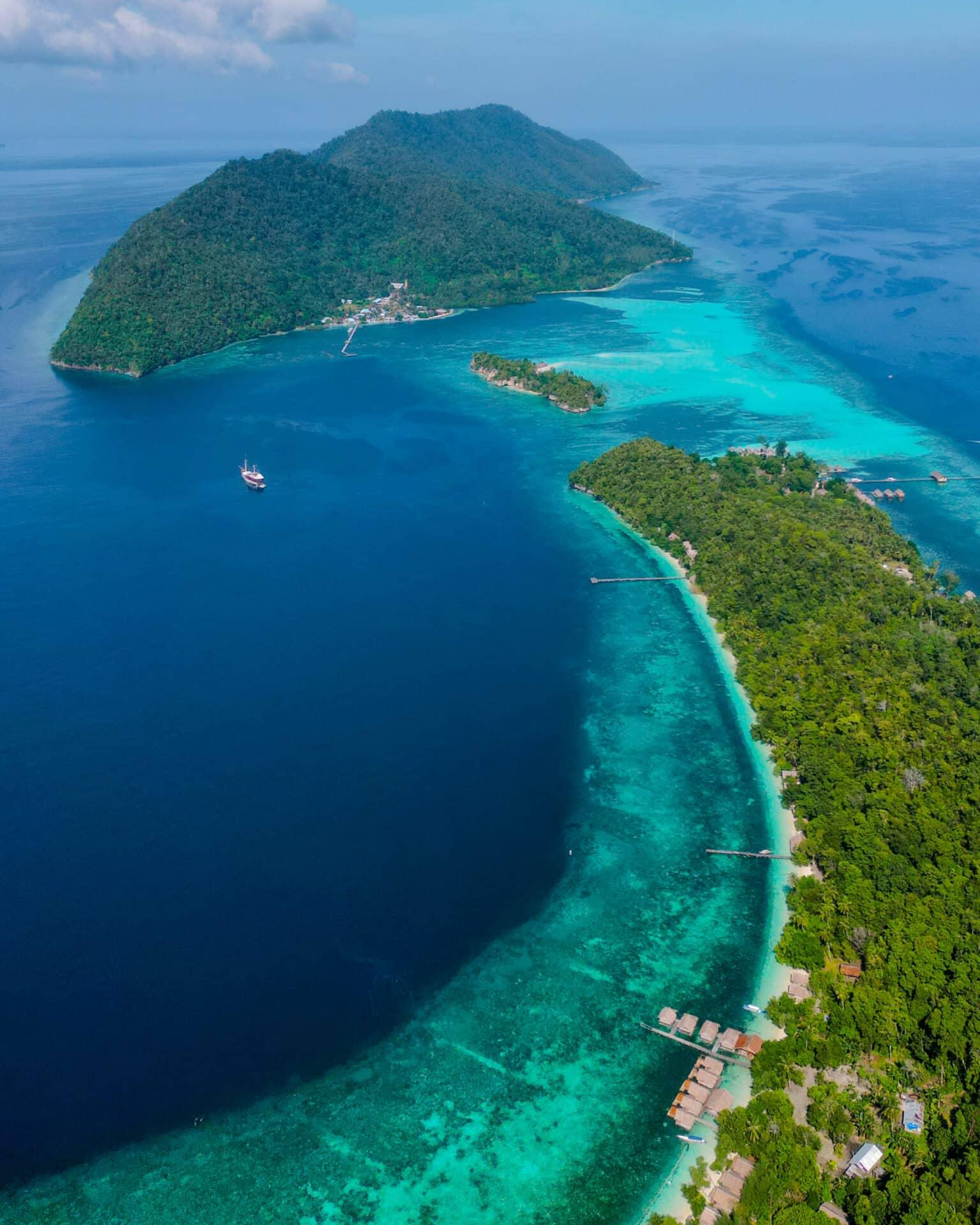 Kri Island viewed from above, green and surrounded by turquoise sea.