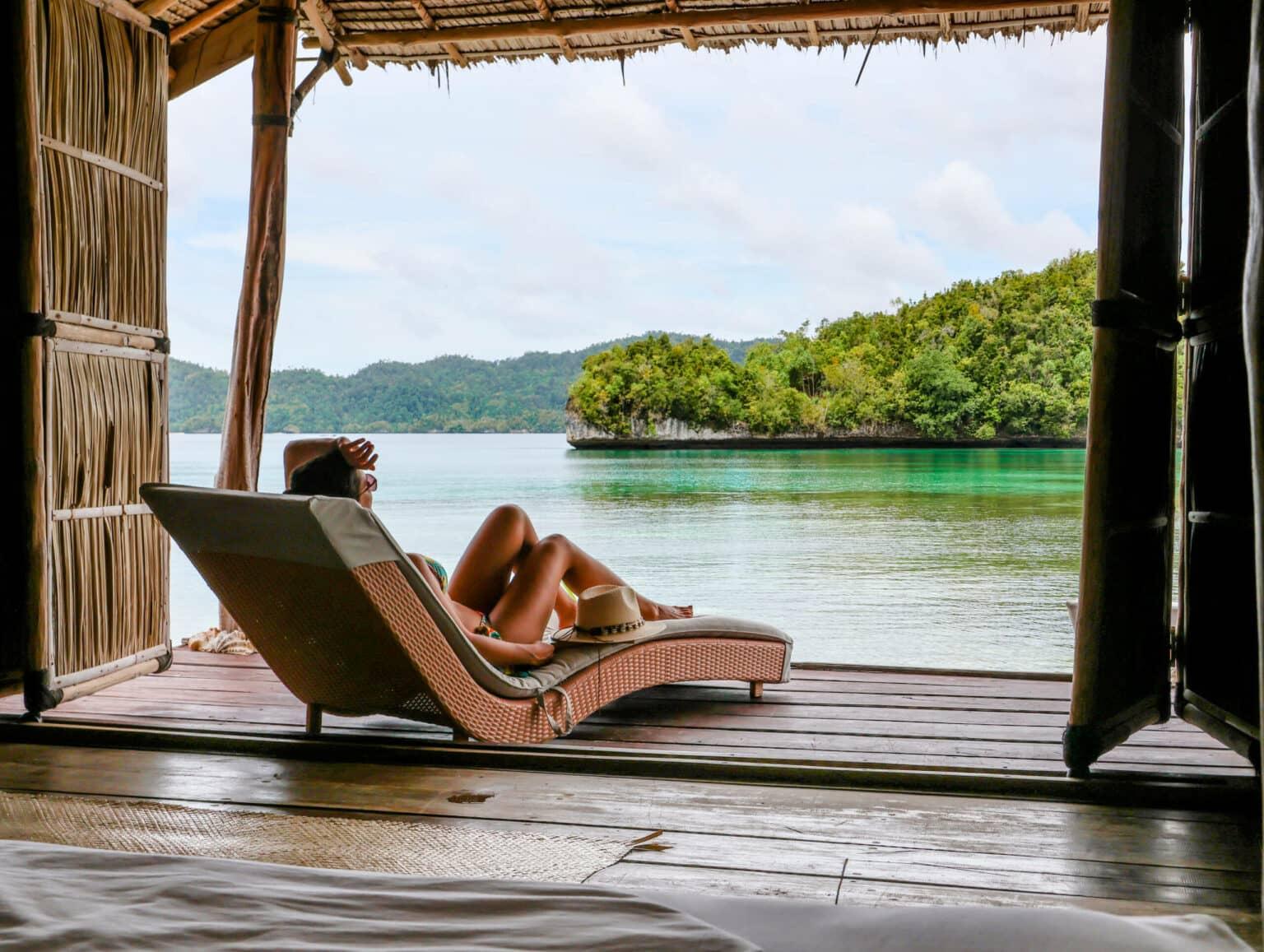 Blogger Nina sunbathing on a lounger, looking out over the sea of Raja Ampat