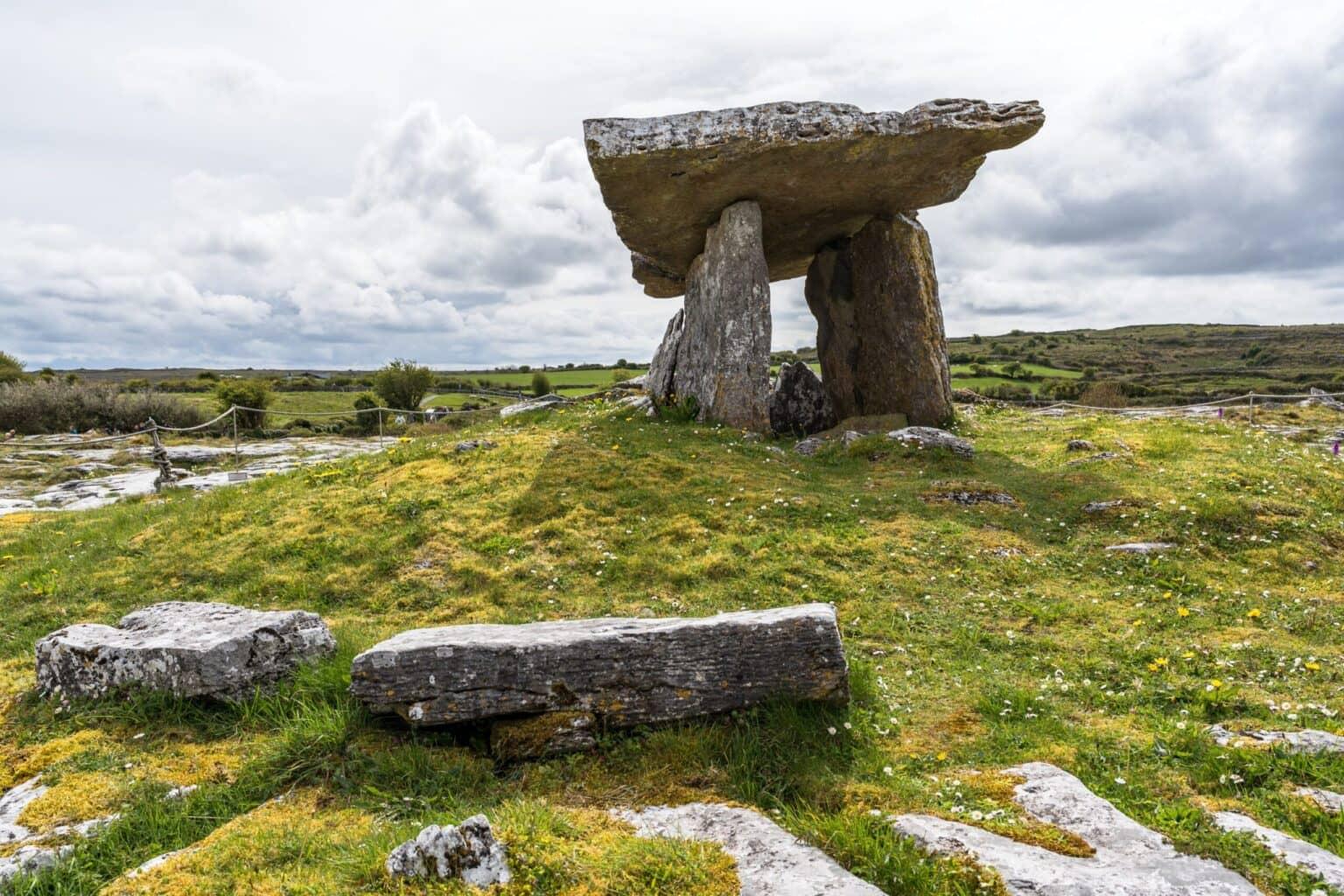 Una tumba prehistórica - roca apilada en un prado verde.