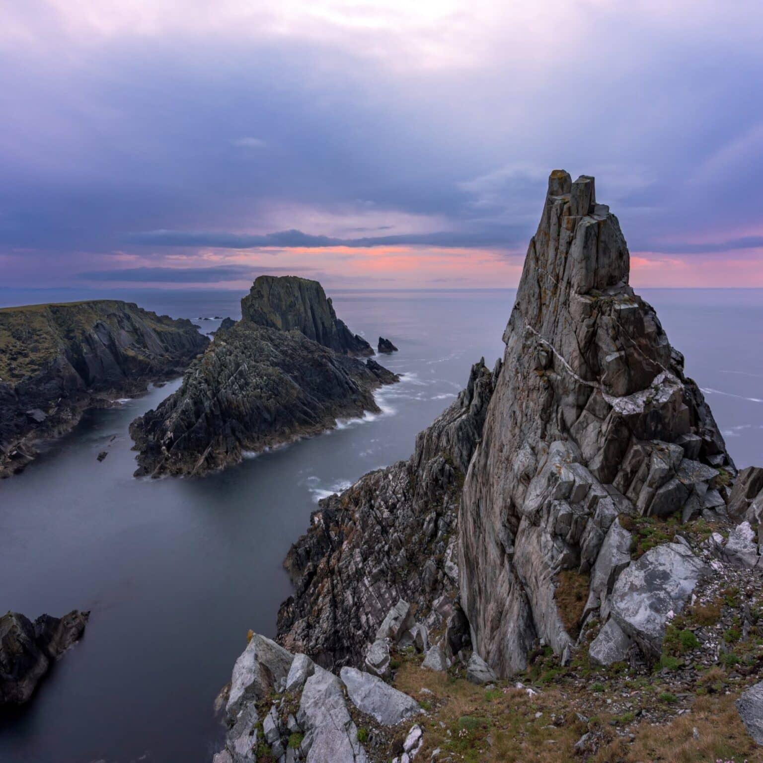 Rocas escarpadas iluminadas por la luz del atardecer en la costa de Malin Head.