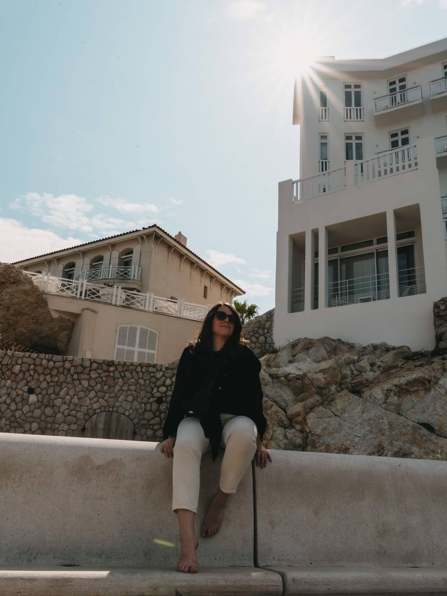 Blogger Laura sitting on the promenade at Plage des Catalans beach.