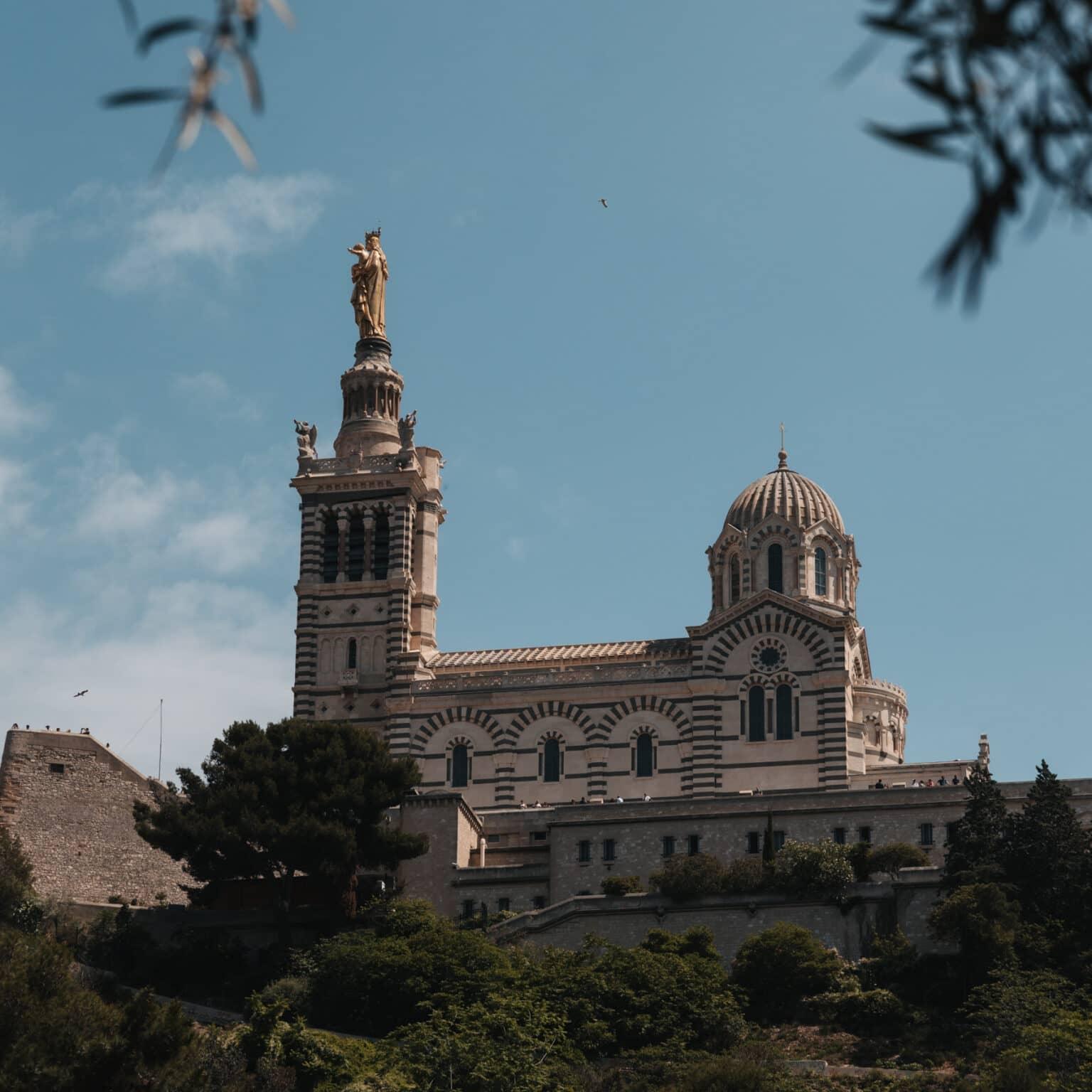 View of La Notre-Dame de la Garde, with its two towers and surrounded by a wall.