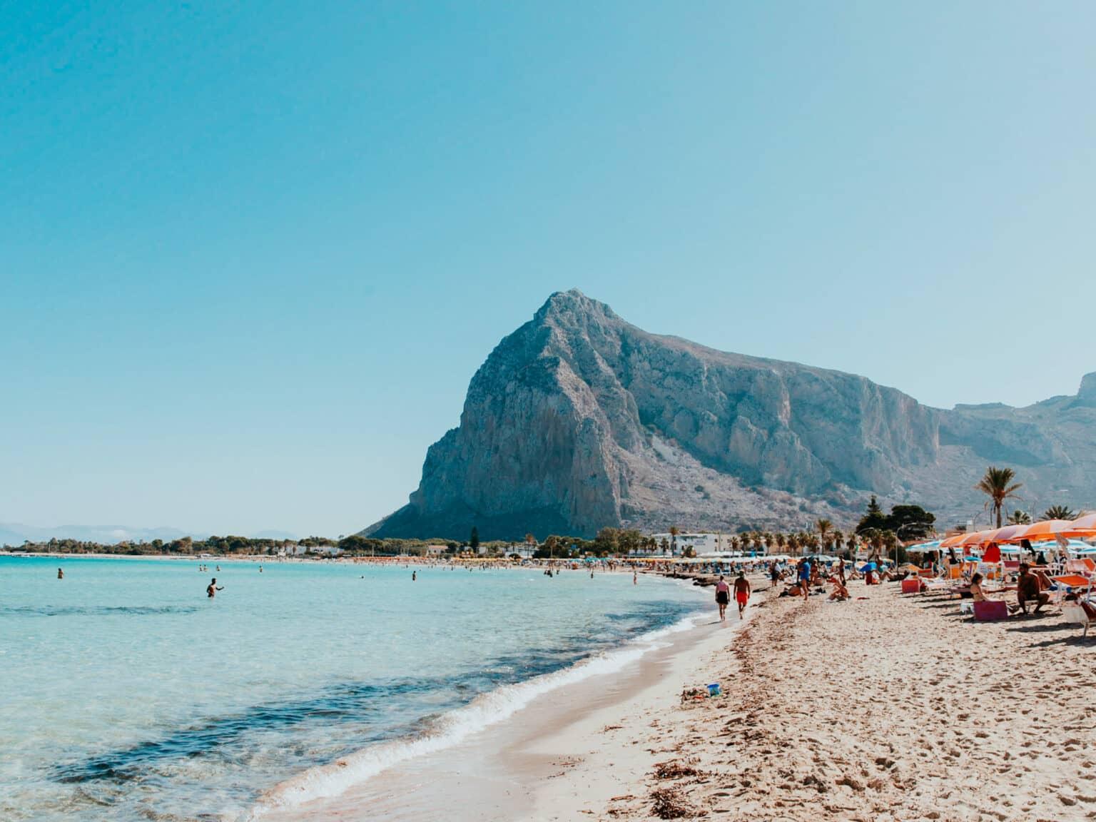 The beach of San Vito Lo Capo surrounded by hills and turquoise water.