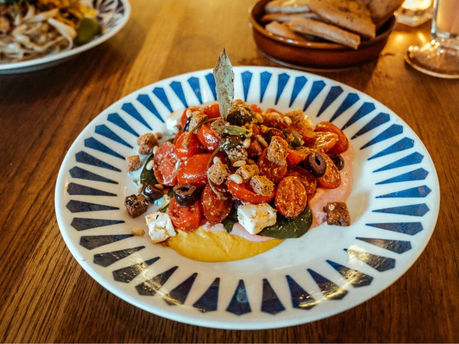 La Ensaladas para los Dioses de Flax & Kale en Barcelona estarán llenas de espinacas, tomates cherry, aceitunas Kalamata, alcaparras y nueces sobre hummus de colores de arcoíris, no solo es hermosa, sino que también es saludable y deliciosa.