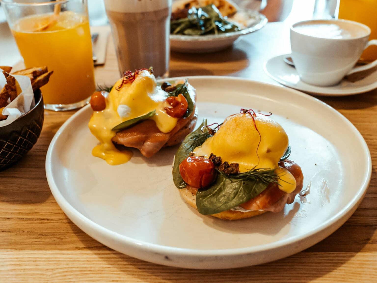 El Alaska Royale Benedict de The Egg Lab en Barcelona es simplemente delicioso: huevos benedictinos en un bagel de amapola con crema de trufa, hierbas, tomates cherry, espinaca y salmón con una salsa de miel y mostaza.