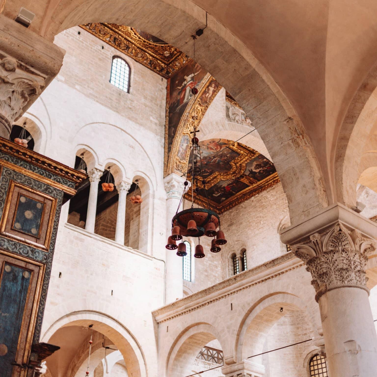 The interior of the Basilica of San Nicola adorned with decorated ceilings and golden elements.
