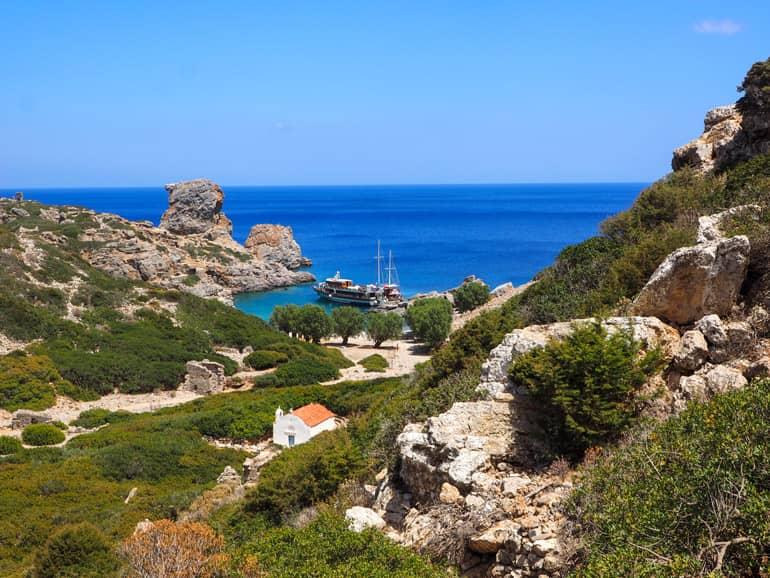 At Ta Palátia Beach, rock formations jut out into the turquoise sea, the ruins of houses from Syrian pirates are scattered along the hillside of the abandoned settlement of Árgos.