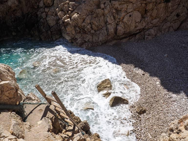 A ladder leads down the steep rock formation to the pebbly Chándakas Bay.