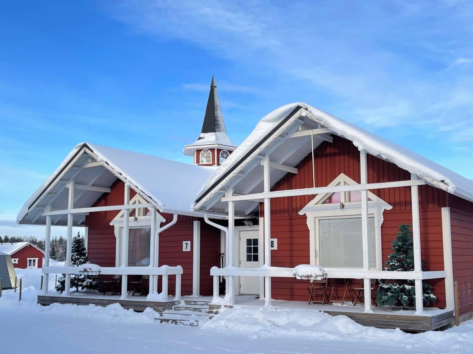 In red-and-white painted wooden cabins, guests can stay in the Christmas Village in Rovaniemi.