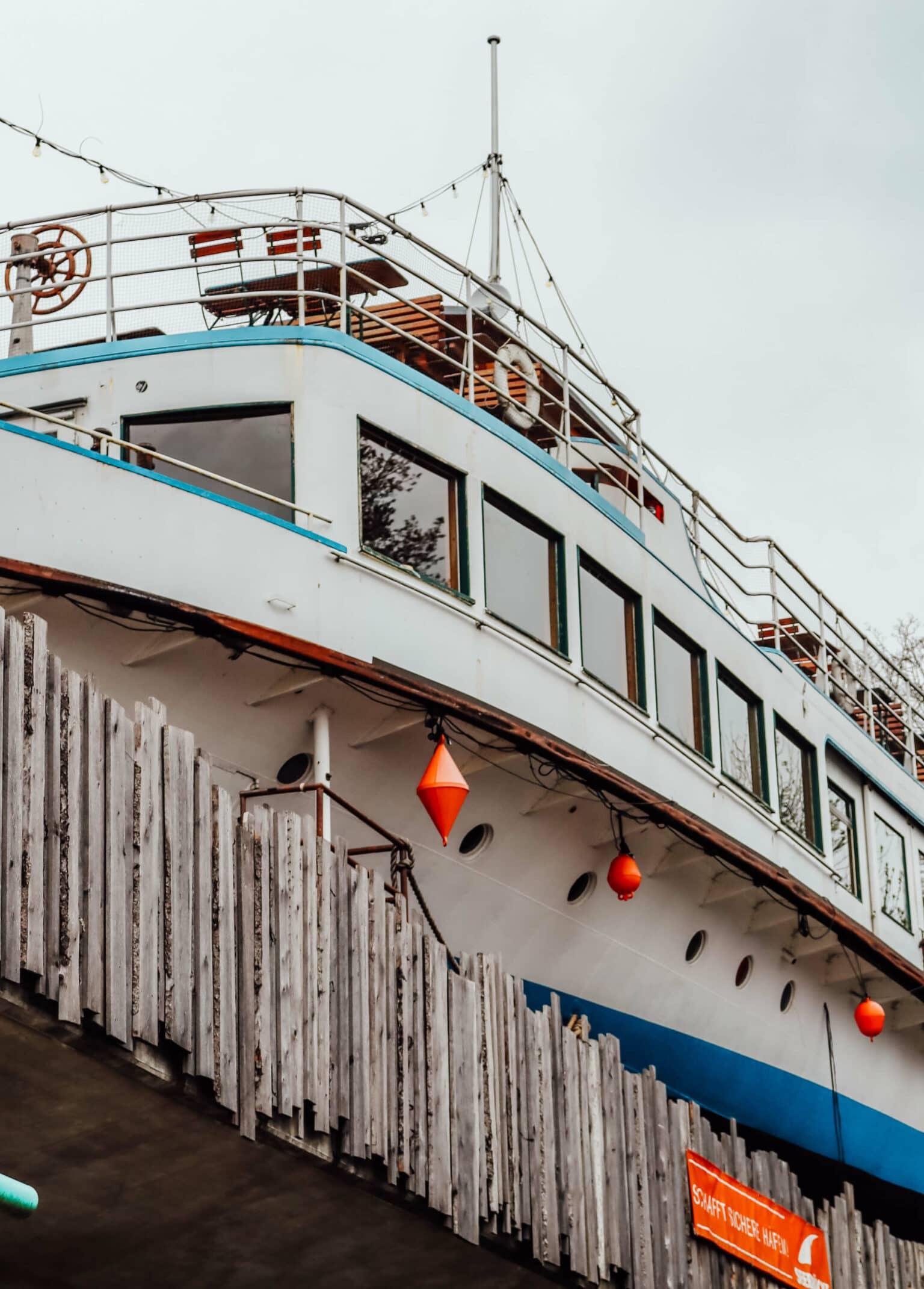 An old ship with chairs and tables on deck on a bridge - the Alte Utting in Munich.