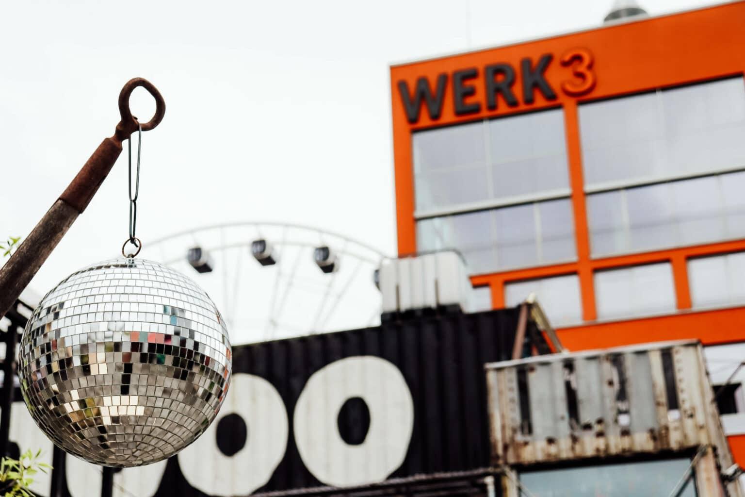 The trendy Munich Werksviertel with the orange high-rise "Werk 3", the Umadum Ferris wheel, and disco ball decor in the Container Collective.