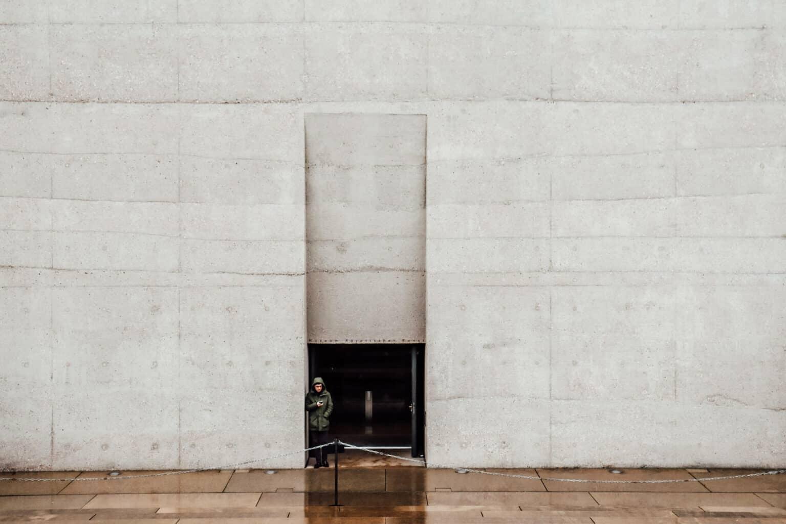 A man stands at the entrance of the SMÄK in Munich.