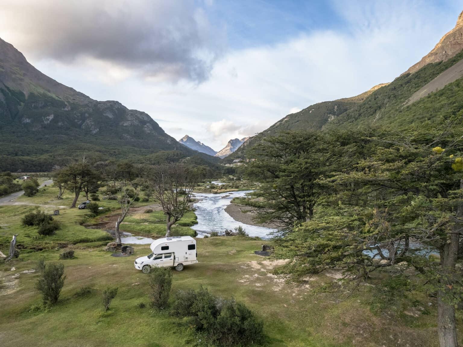 Un camión camper en un valle de montaña con río en Tierra del Fuego.