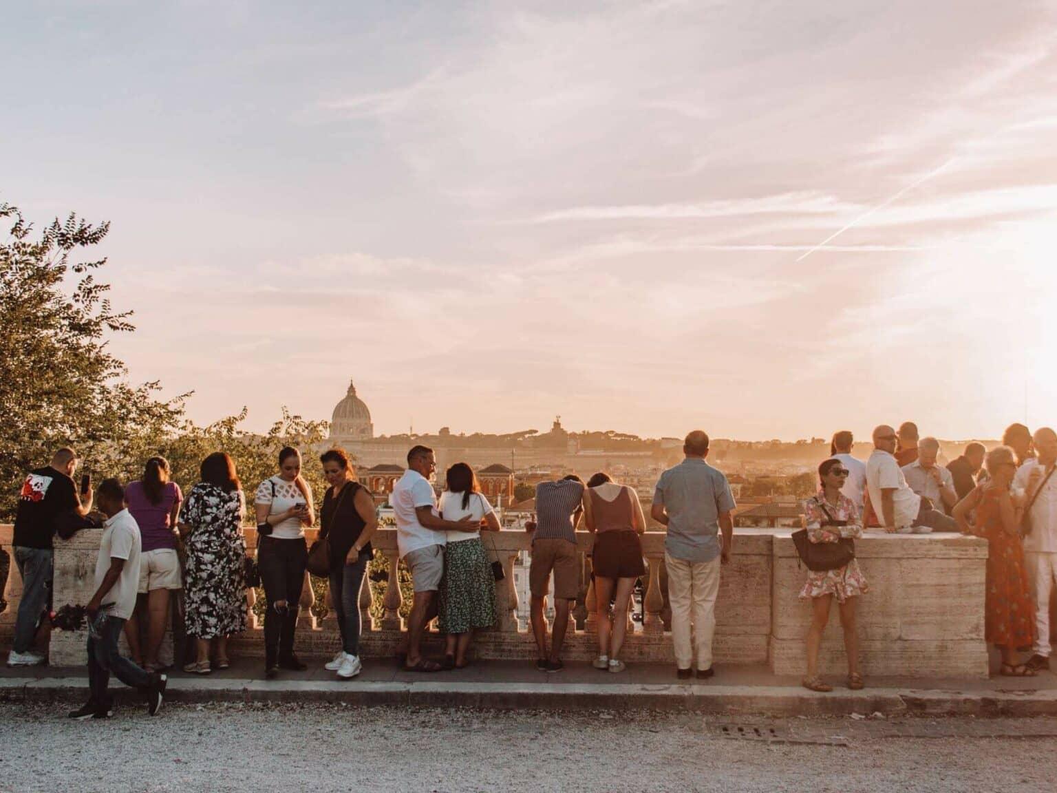 Muchas personas disfrutan del atardecer en la colina Pincio en Roma con vistas a la ciudad.
