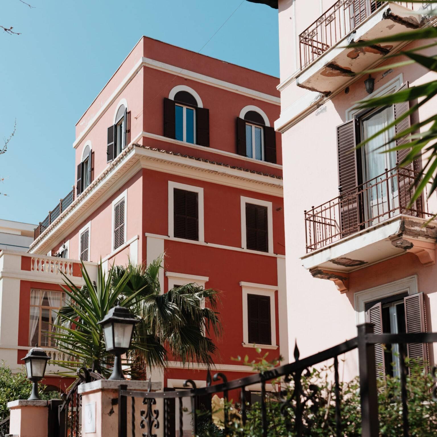 Residencias históricas de verano con fachadas coloridas y palmeras en Lido di Ostia.