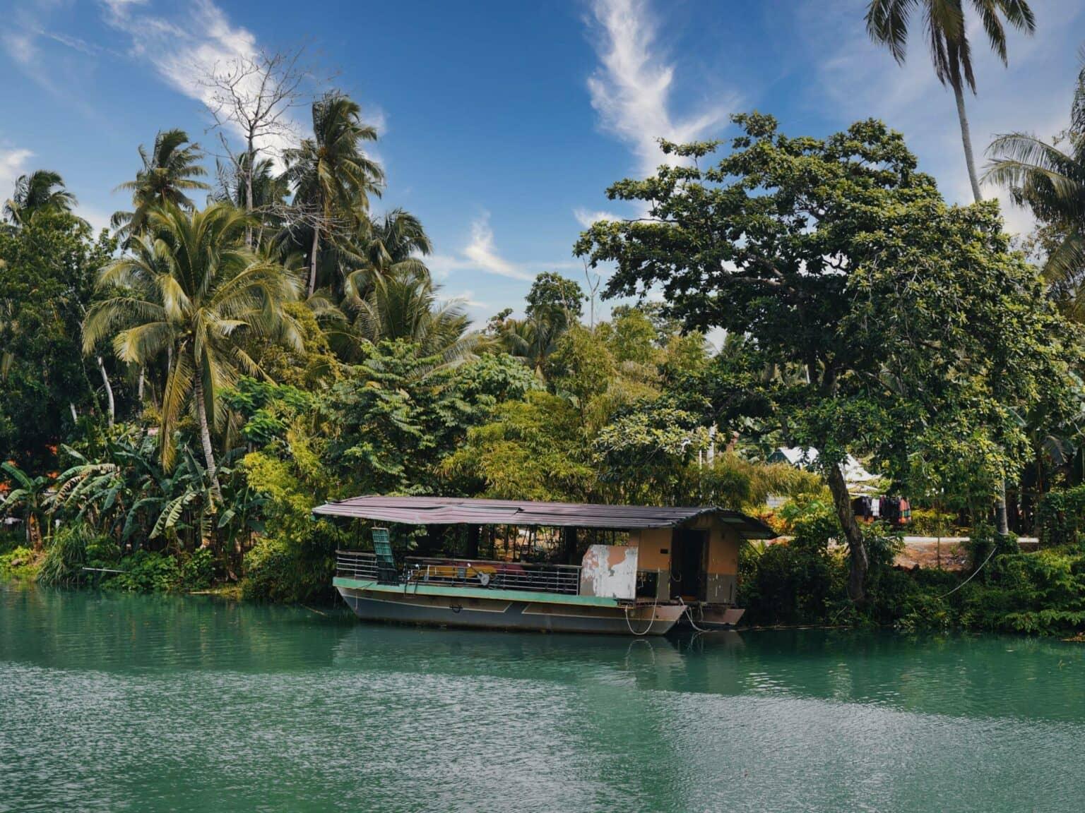 Un pequeño barco de madera se encuentra en la orilla del río Loboc en Bohol.