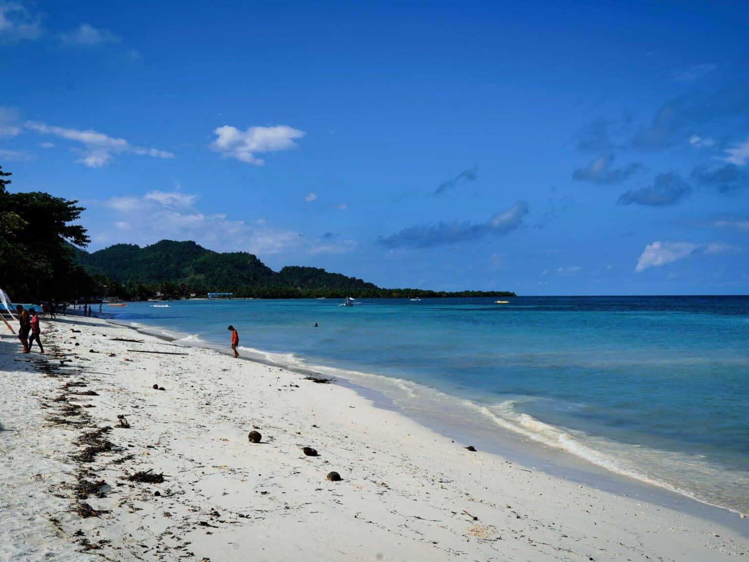 Una hermosa playa de arena con mar azul y cielo azul en Bohol.