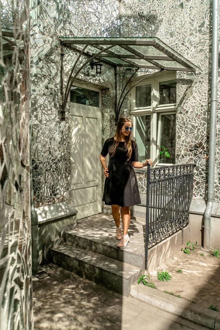 Una mujer está frente a una puerta de casa.