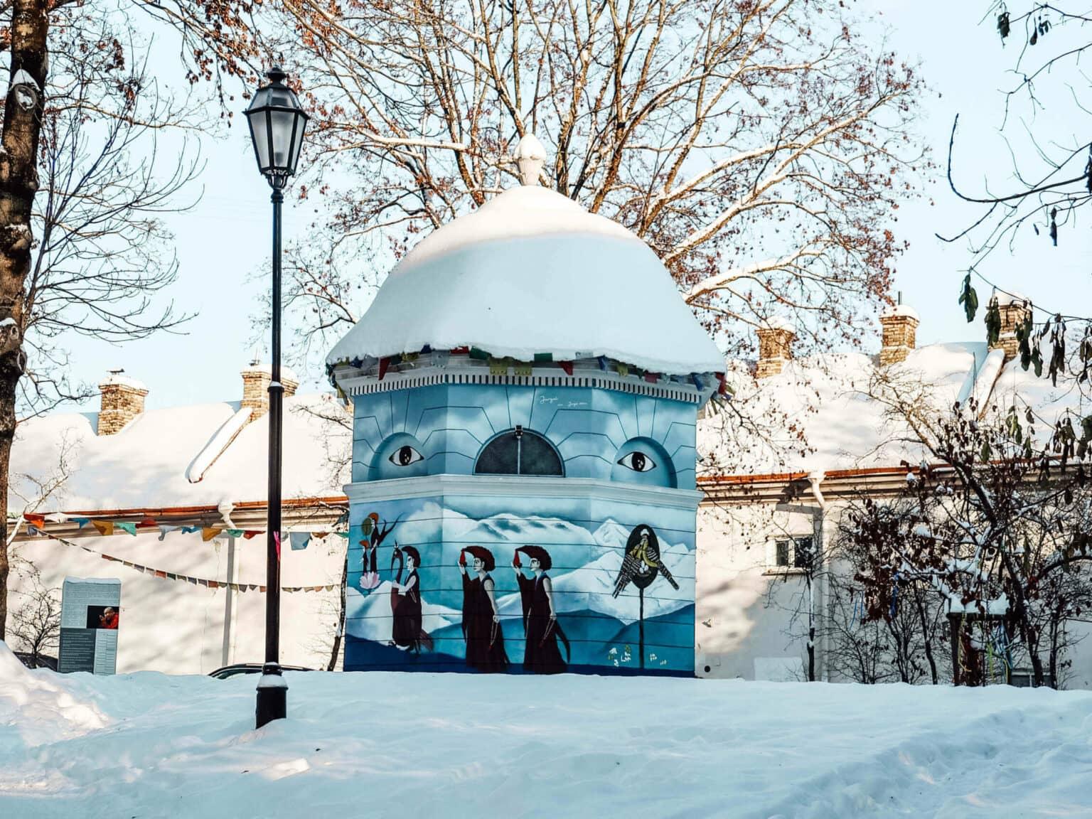 Un edificio redondo pintado con arte urbano en el barrio de Uzupis en Vilnius.