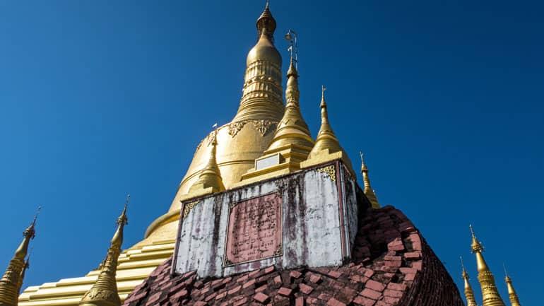 The golden tower of the Shwemawdaw Pagoda in Bago, Myanmar, rises into the sky.