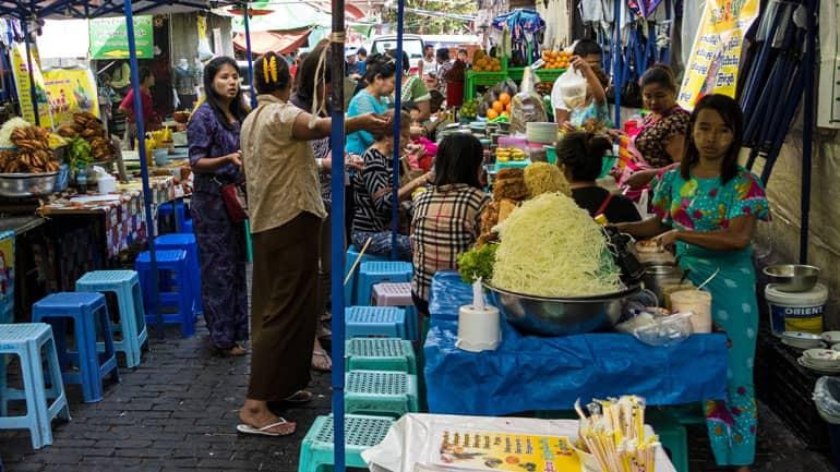 A food stall in the courtyard of the Bogyoke Aung San Market in Myanmar is bustling with activity.