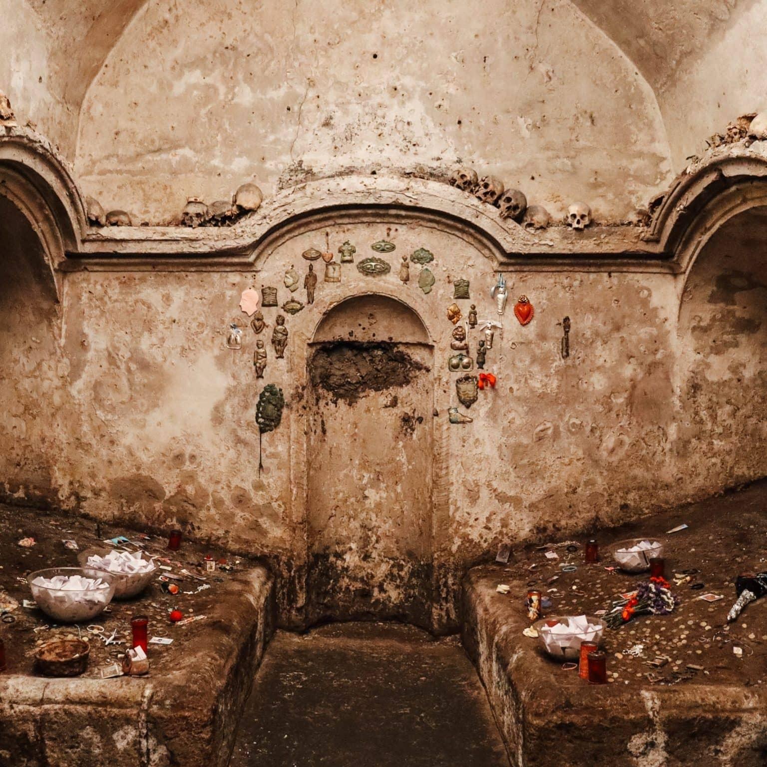 The very dilapidated crypt of Santa Luciella with rounded arches, where candles and notes have been left.