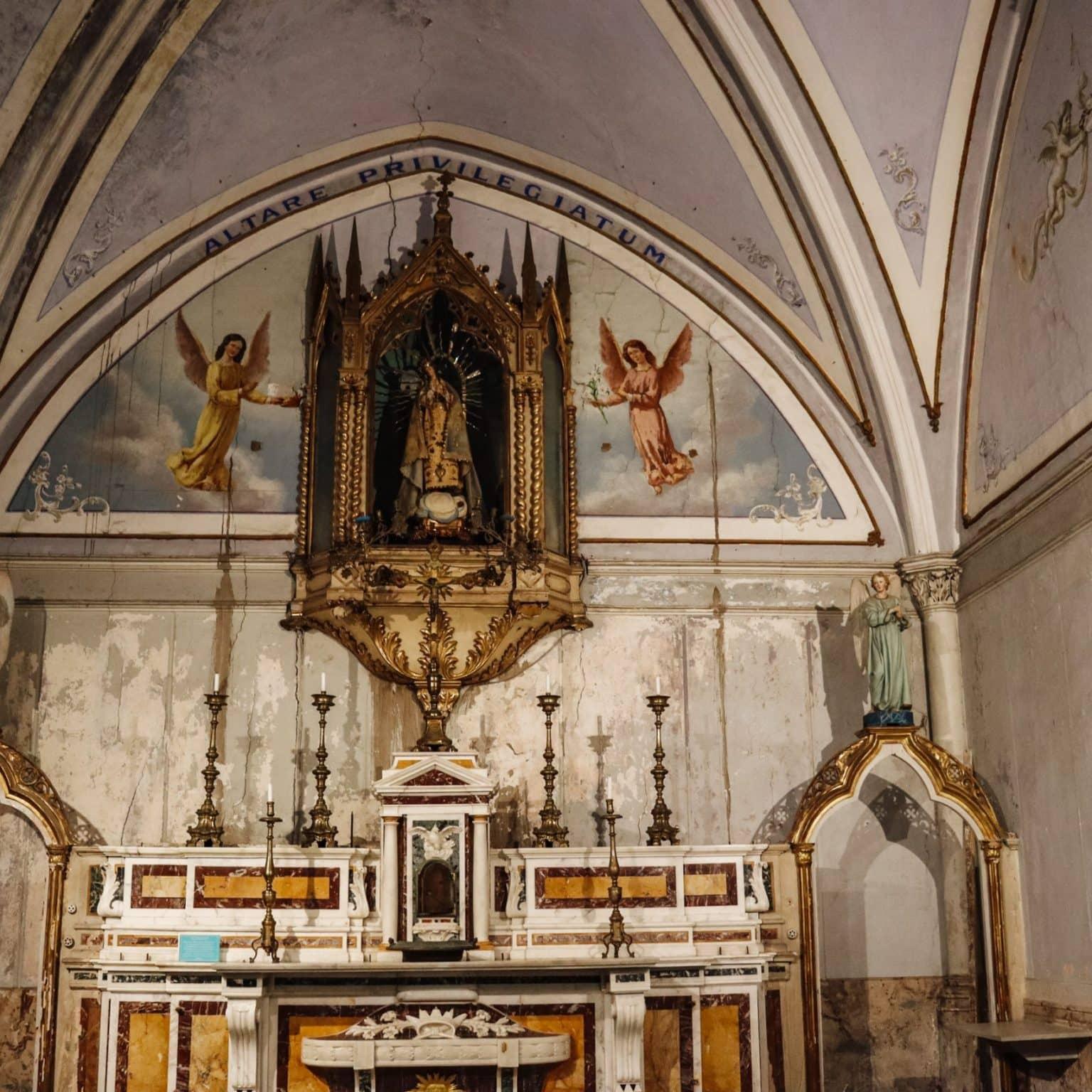 The interior of Santa Luciella church is painted in white, with many colorful religious motifs on the walls.
