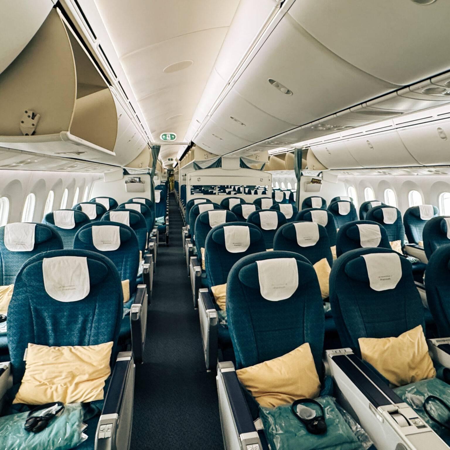 The cabin of Vietnam Airlines Economy Class with blue seats and additional blankets and pillows.
