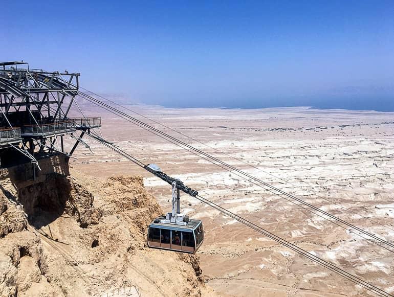 Una góndola del teleférico sube por la montaña de Masada en medio del paisaje desértico de Israel.