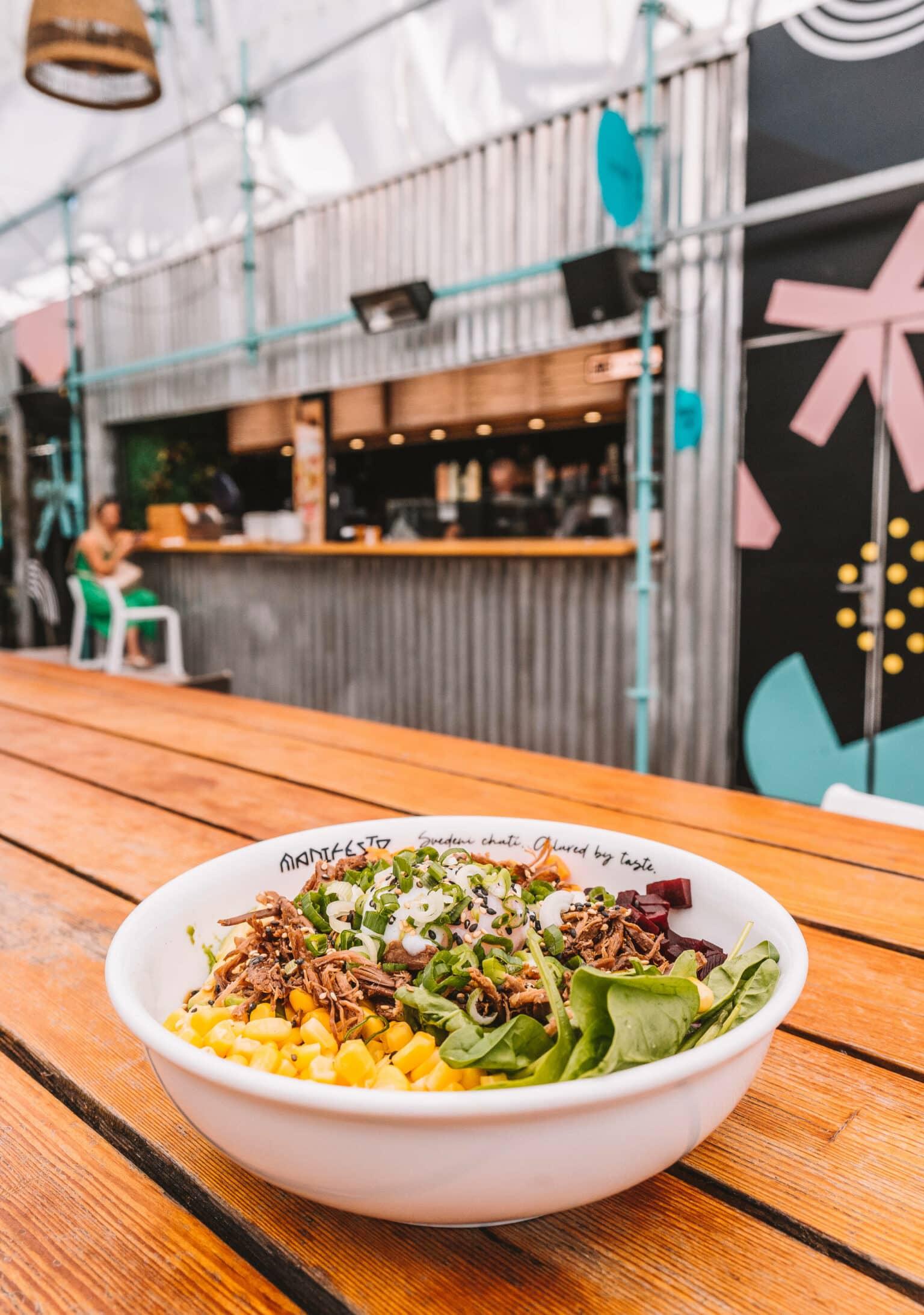 A poke bowl on a wooden table at the Manifesto Anděl Food Market in Prague.