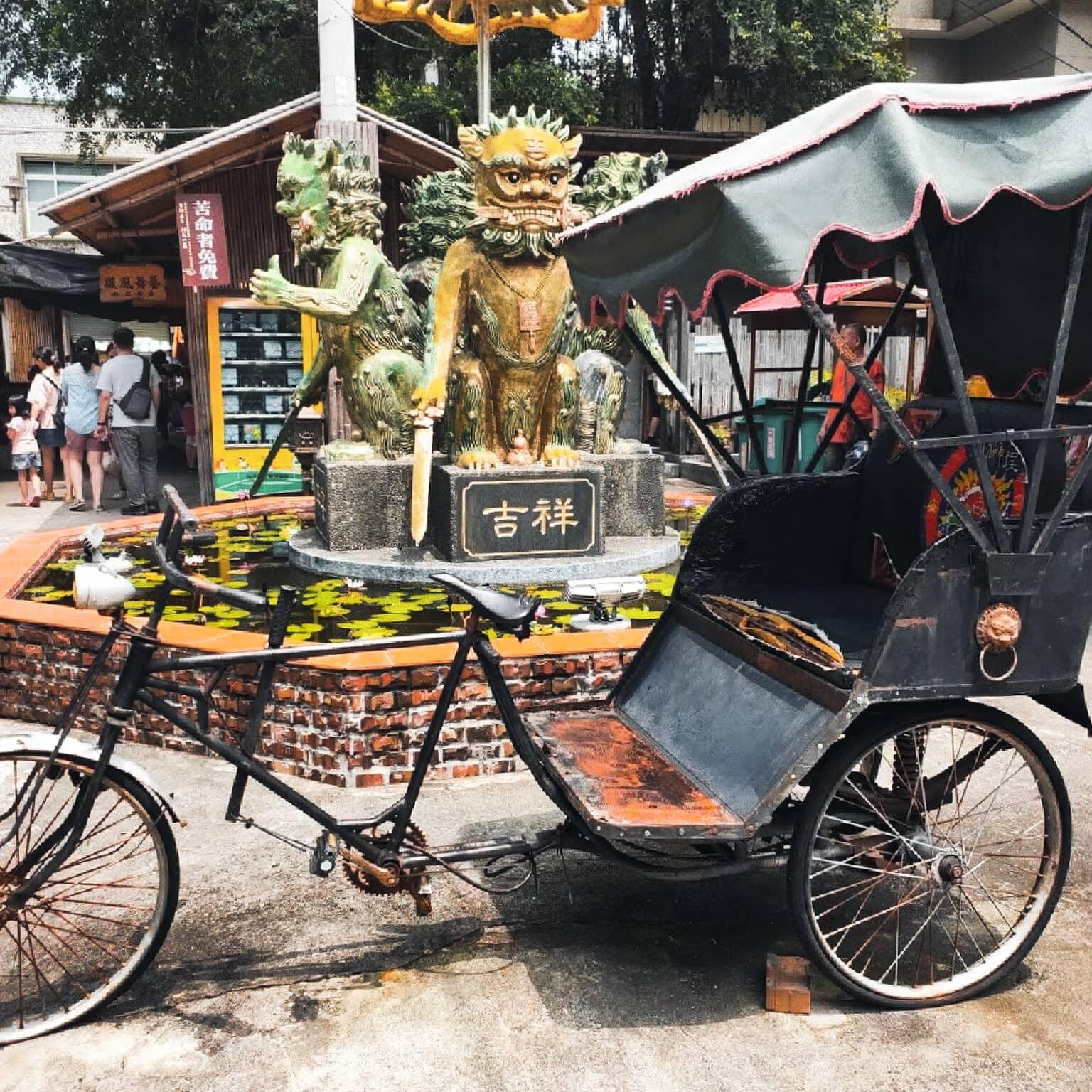 An old tricycle stands in the middle of a historic street.