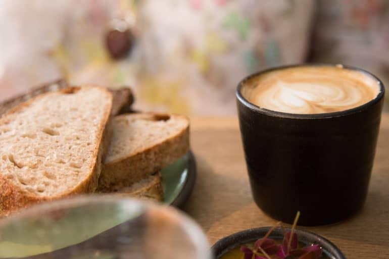 Sobre una mesa en Mad & Kaffe en Copenhague se sirvieron pan y un capuchino con un corazón de espuma de leche.