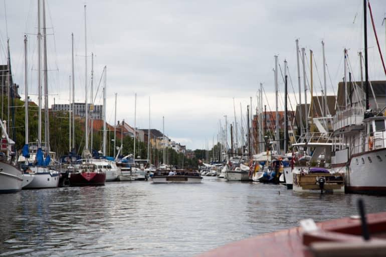 En Copenhague, en Christianshavn, muchos barcos y veleros están anclados a los lados.