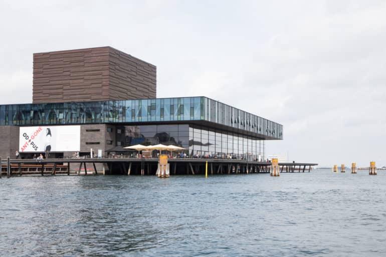 En Copenhague se encuentra el Teatro Real con su gran fachada de ventanas en medio del agua.