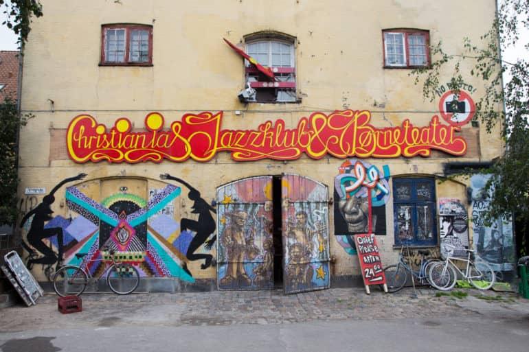 Una pared de casa un poco deteriorada con graffiti adorna la entrada del club de jazz Christiania, ubicado en Copenhague.