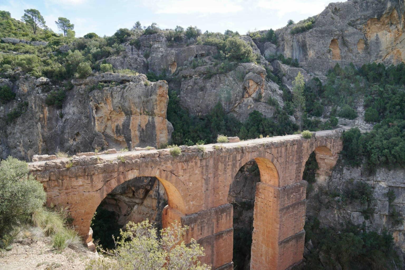 The Peña Cortada Aqueduct lies between mountains near Valencia.