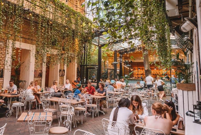 Viaje a Budapest: Patio de un restaurante con plantas que cuelgan del techo.